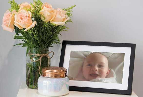 The Skylight Frame 10-inch Wi-Fi frame sat on a table with flowers